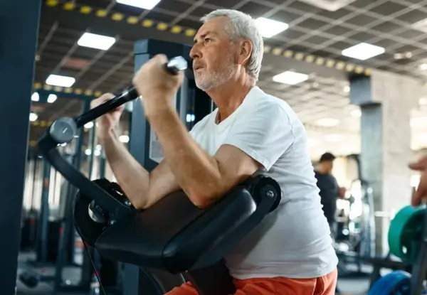 Senior gym goer using weights machine