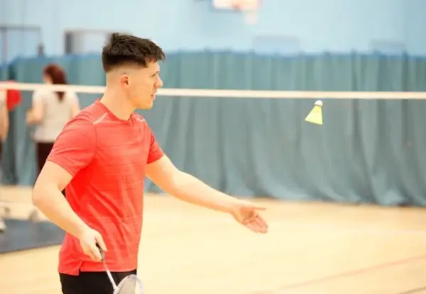 Man serving in badminton match