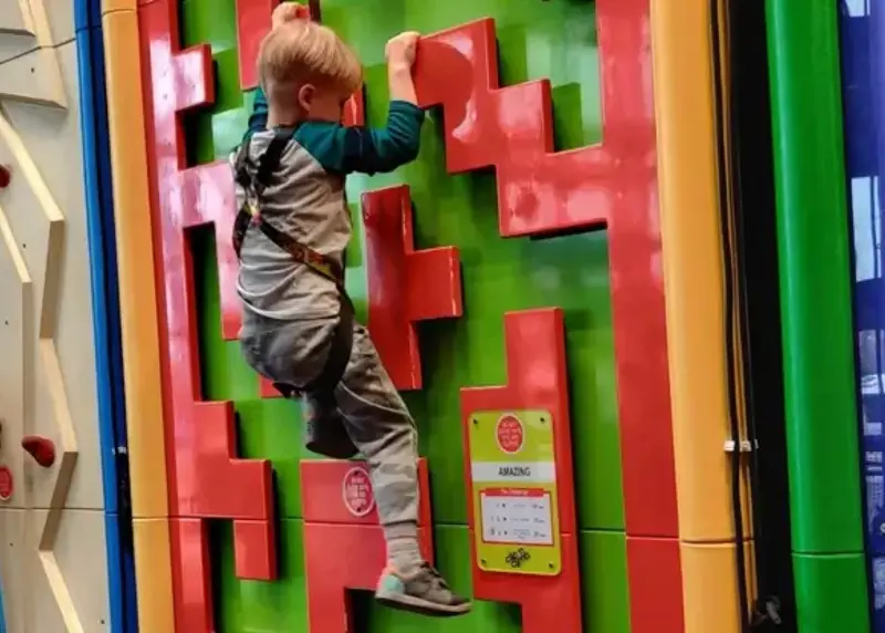 Boy climbing clip n climb wall at The Triangle