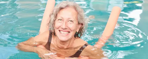 woman in a swimming pool with a float smiling